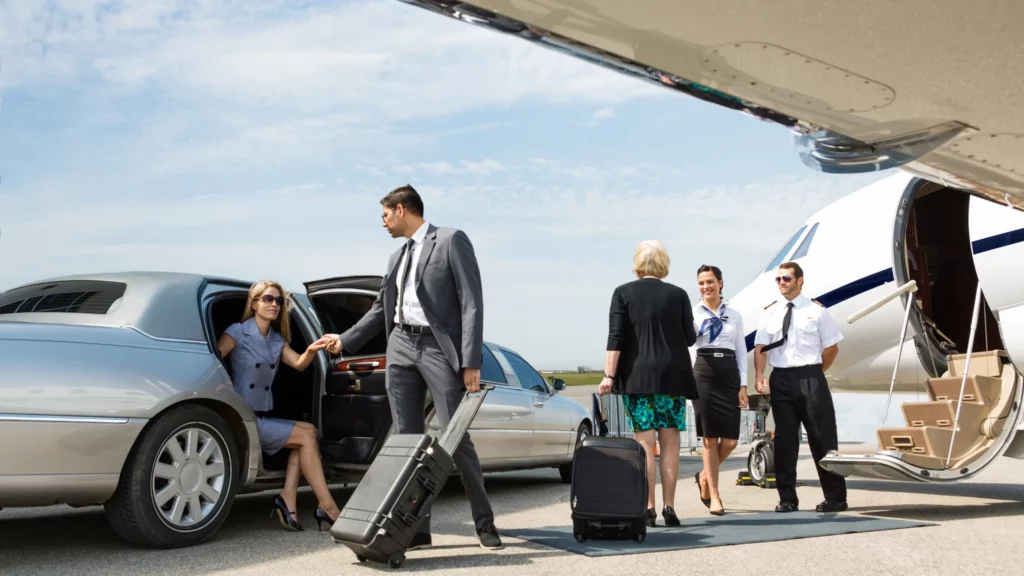 A professional chauffeur opening the door of a limousine for a client.